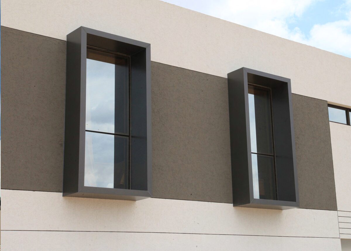 Marcos de ventana en ACM gris oscuro sobre fachada