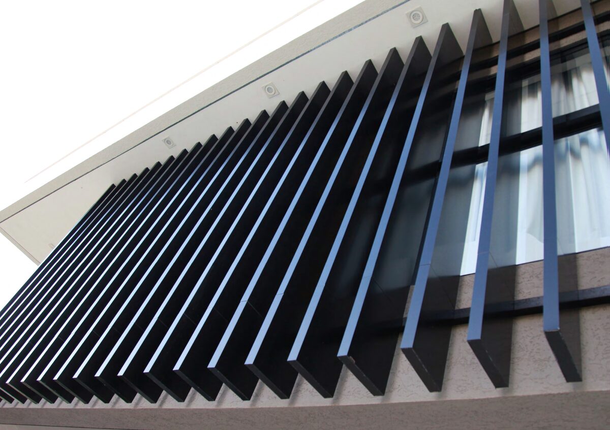 Parasol brise-soleil de lamas negras en ACM sobre ventana