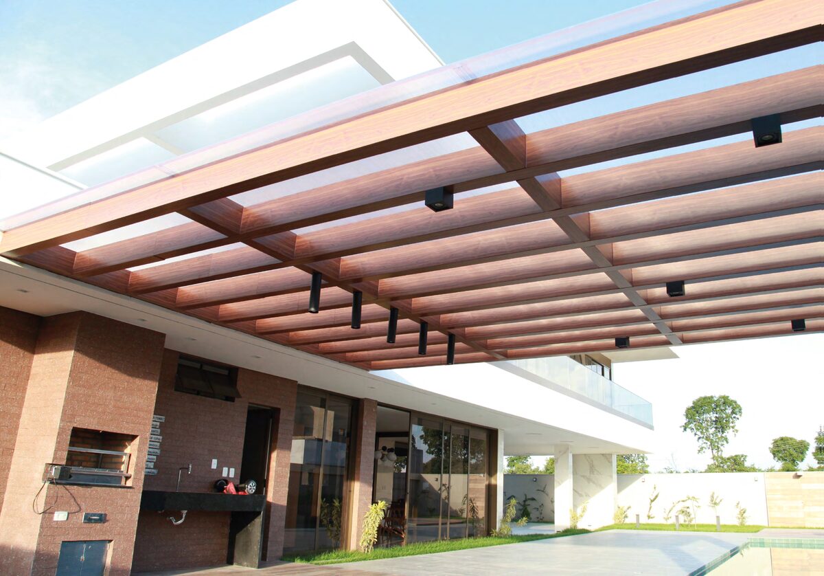 Pérgola en ACM símil madera sobre área de parrilla y piscina